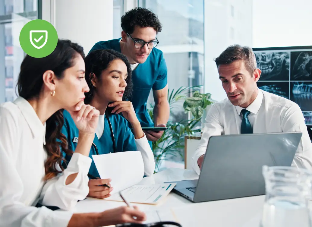 Medical team reviews patient dental X-rays on a laptop, underscoring the role of cybersecurity in keeping patient data secure.